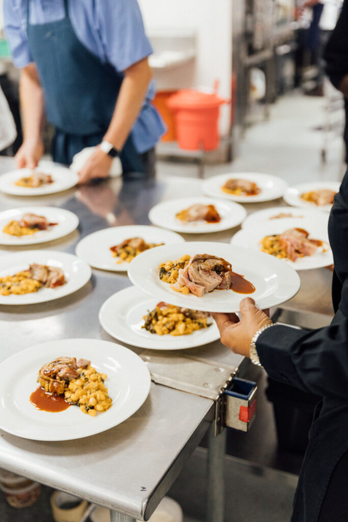 Chefs and servers prepare food for guests at the 2023 Feed Your Mind Gala.