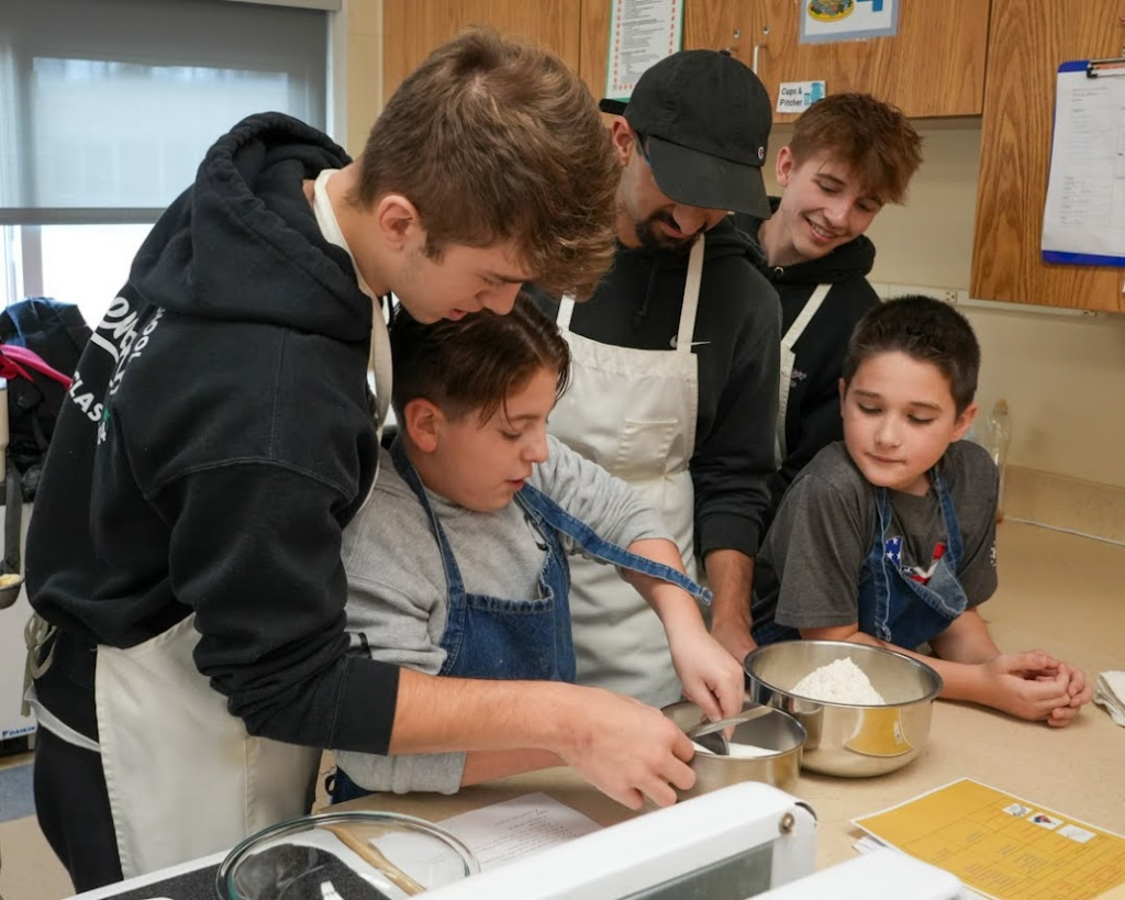 A group of students and teachers bake together as part of a food advocacy project.