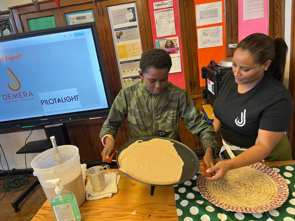 Chicago chef Tigist helps students understand Food Education Standard 1: Food connects us to each other, during a classroom visit. 