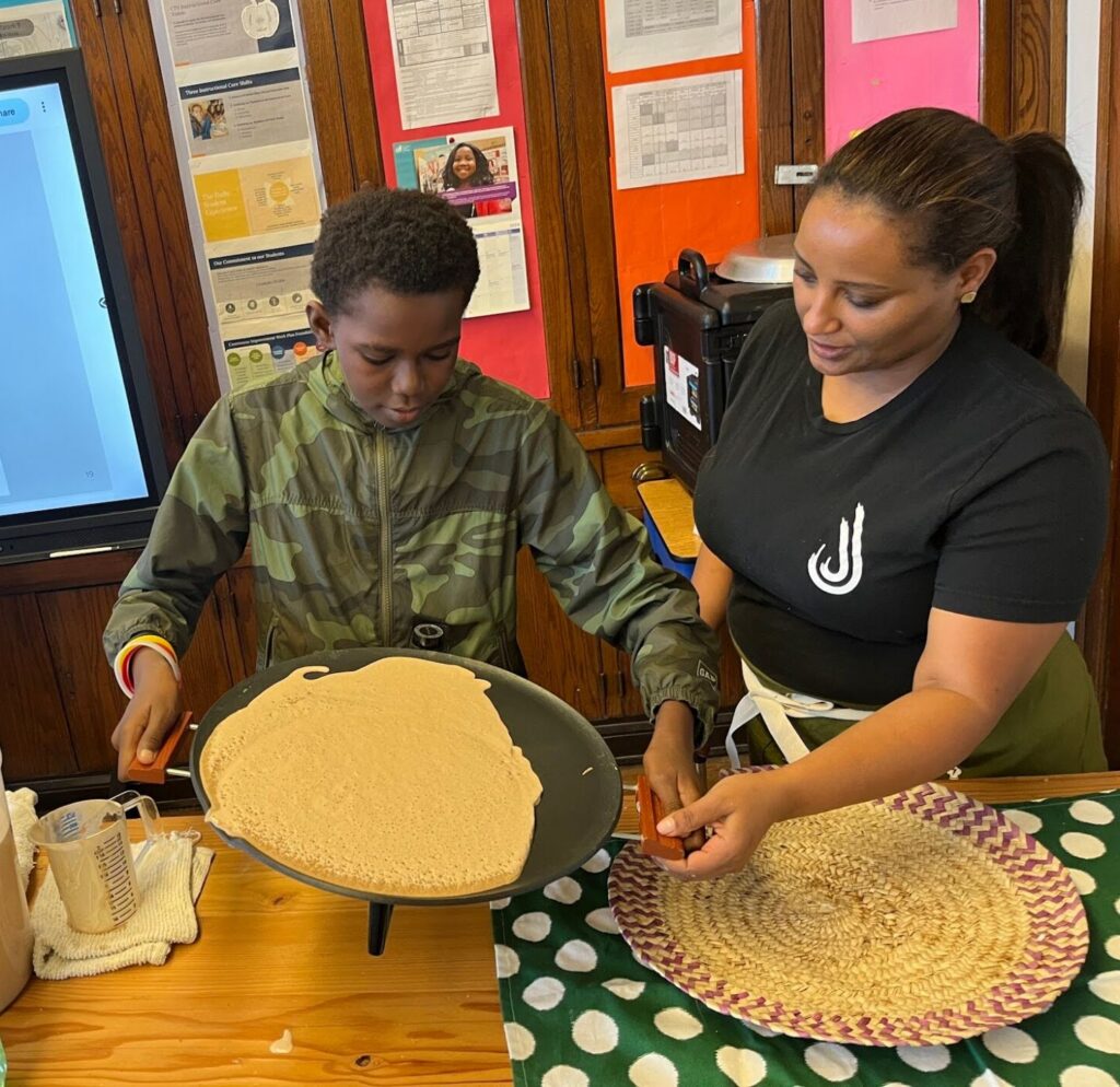 Chicago chef Tigist helps students understand Food Education Standard 1: Food connects us to each other, during a classroom visit.