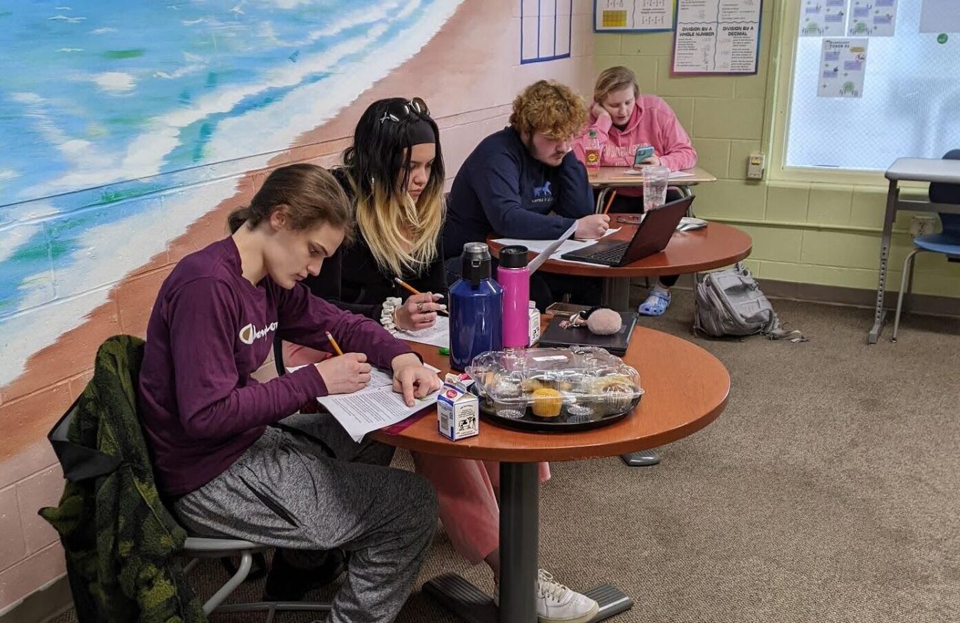 High school special education students sit together at tables to write a letter advocating for food education to continue at their school.