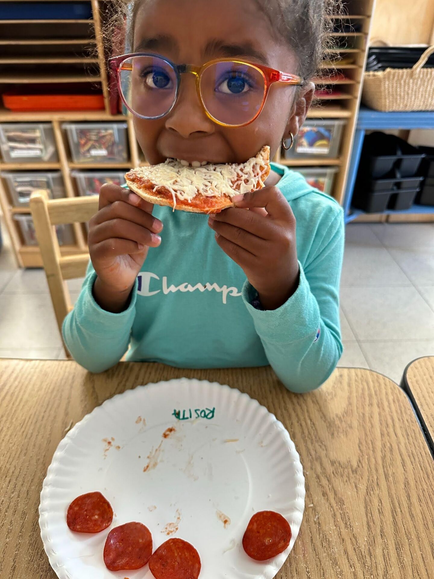 A young student takes a bite of a pizza as part of a hands-on Food Education lesson.