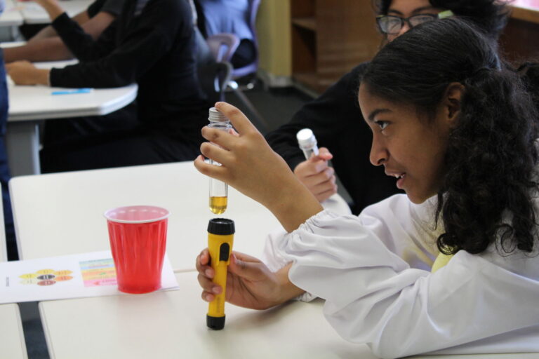 A middle school student examines a honey sample as part of a hands-on Food Education science experiment.